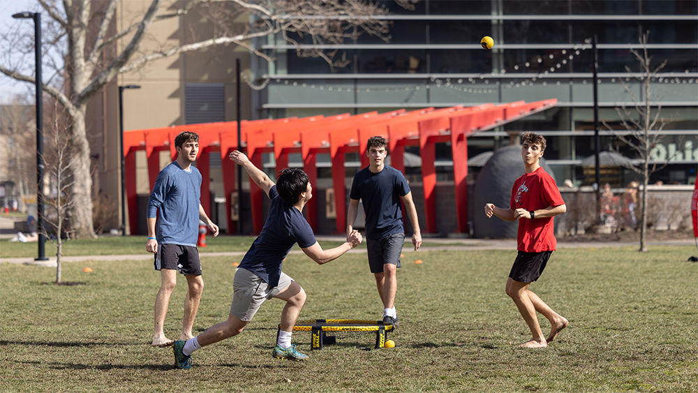 Students play spikeball near the North residence halls on an early Spring/late Winter sunny day.