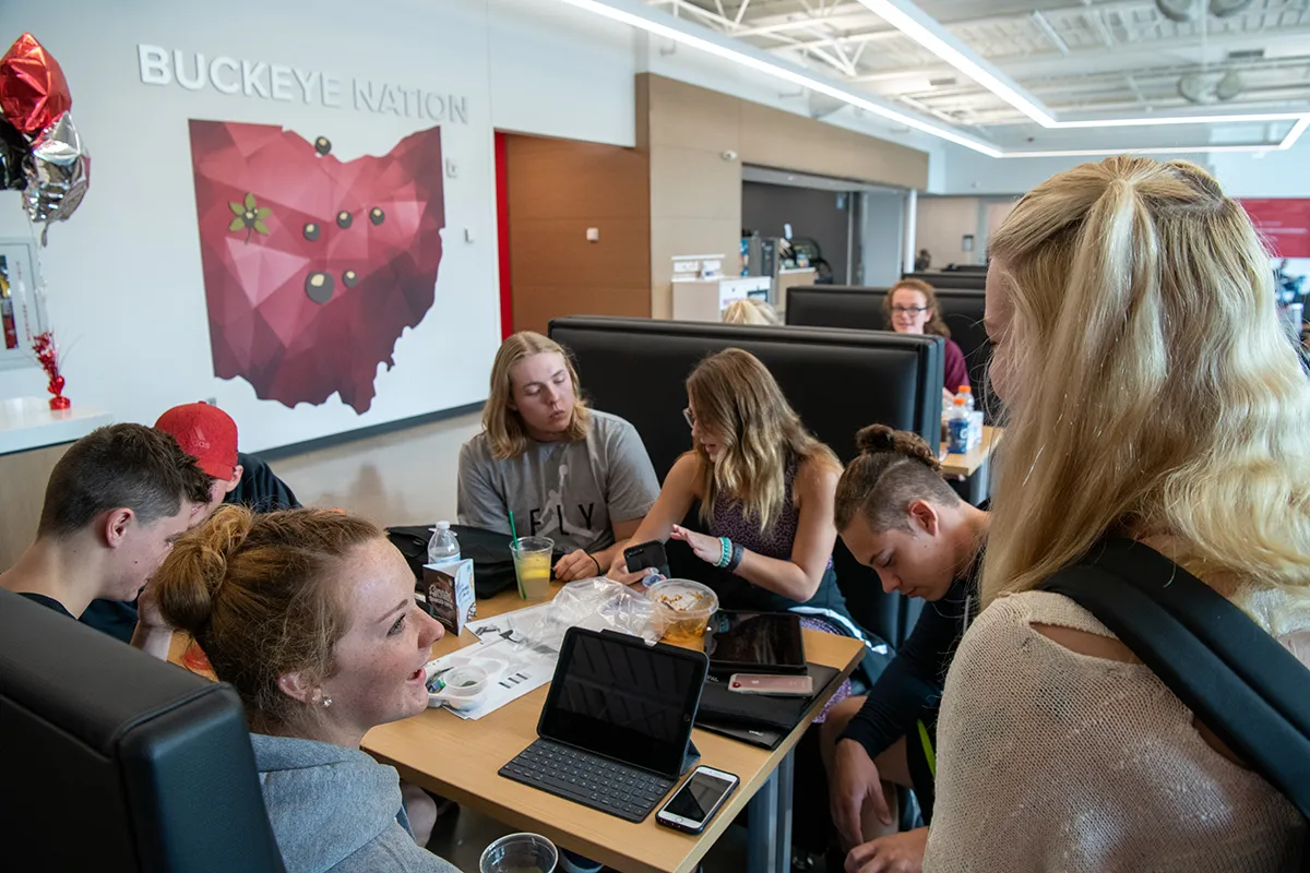 Six students collaborate around a table in the Perry Webb Student Life building at Ohio State Lima.
